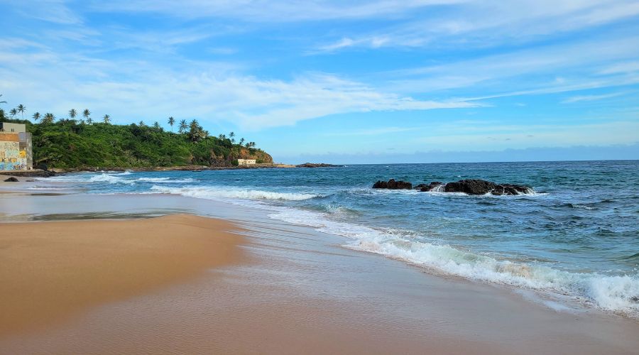 Praia do Buracão com mar azul e faixa de areia em Salvador, Bahia.